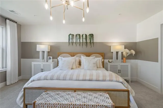 a bedroom with a large bed and a chandelier