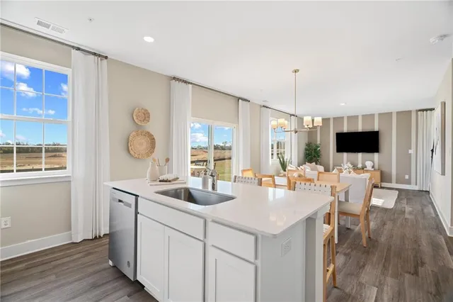 a kitchen with a sink and wooden floor