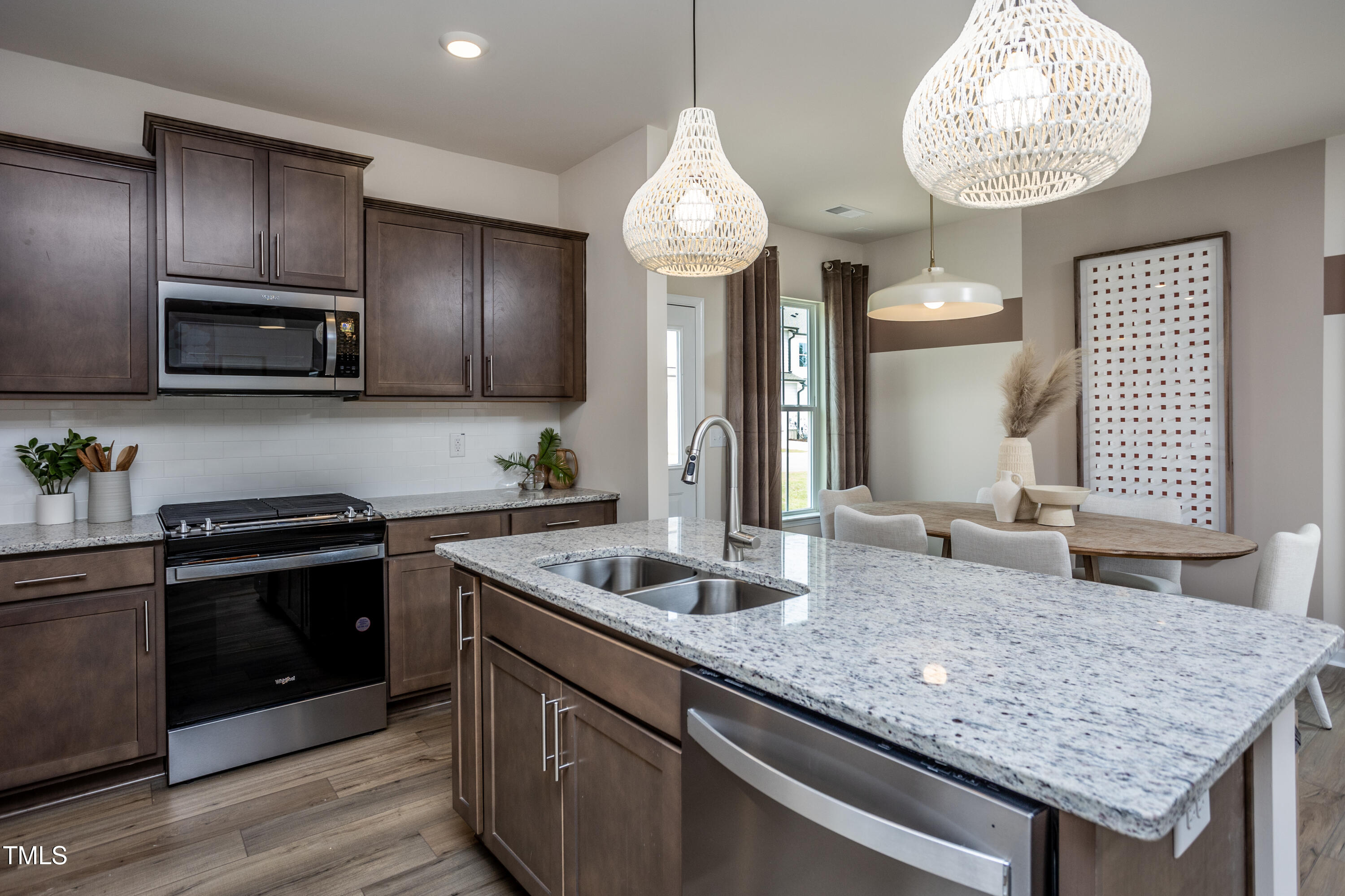 242 Broomside Avenue Raleigh, NC 27603 - Photo 3 of 22 a kitchen with granite countertop stainless steel appliances a stove sink and microwave