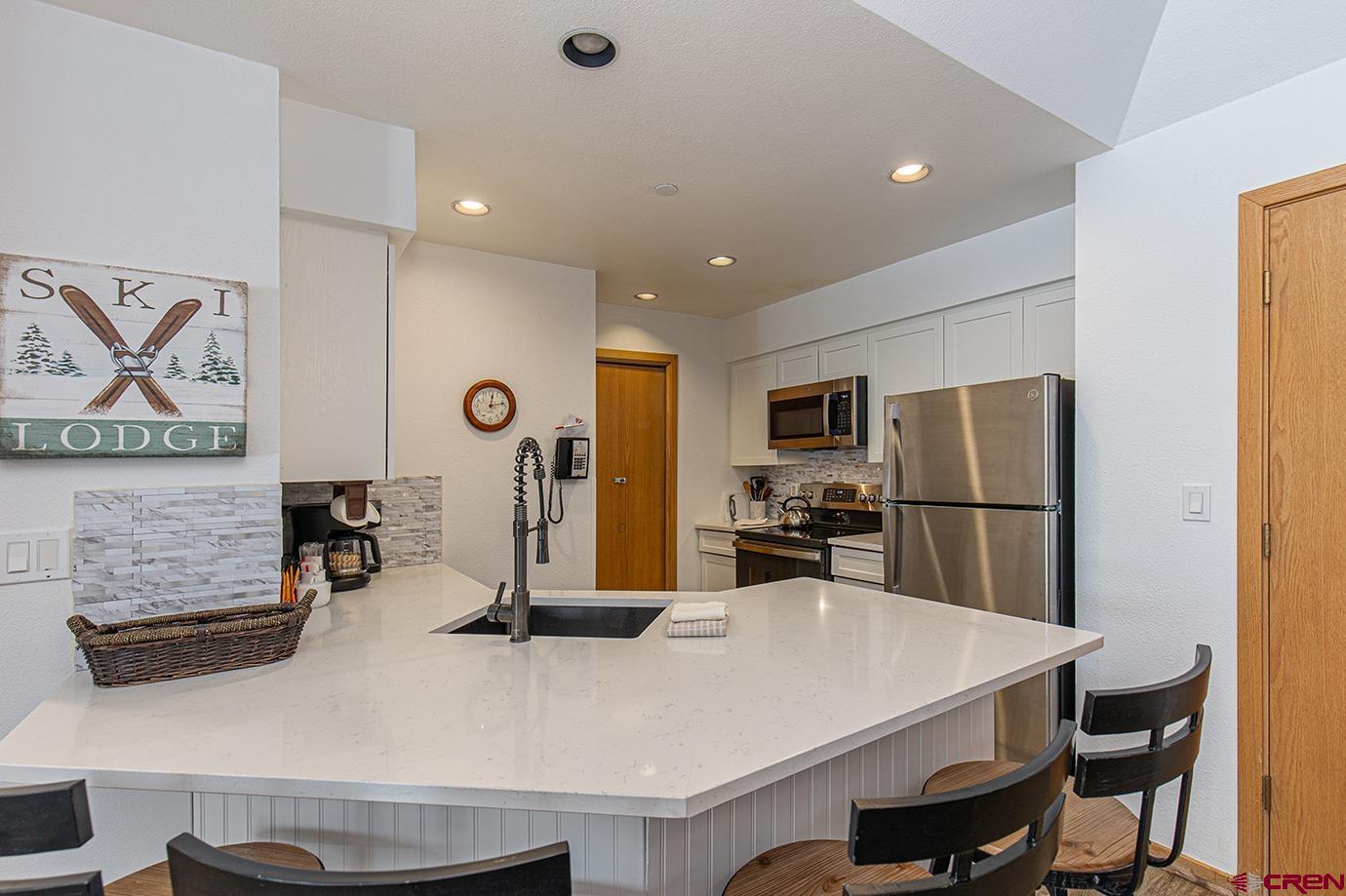 93 Needles Way, Unit 514 Durango, CO 81301 - Photo 2 of 34 a kitchen with refrigerator and chairs