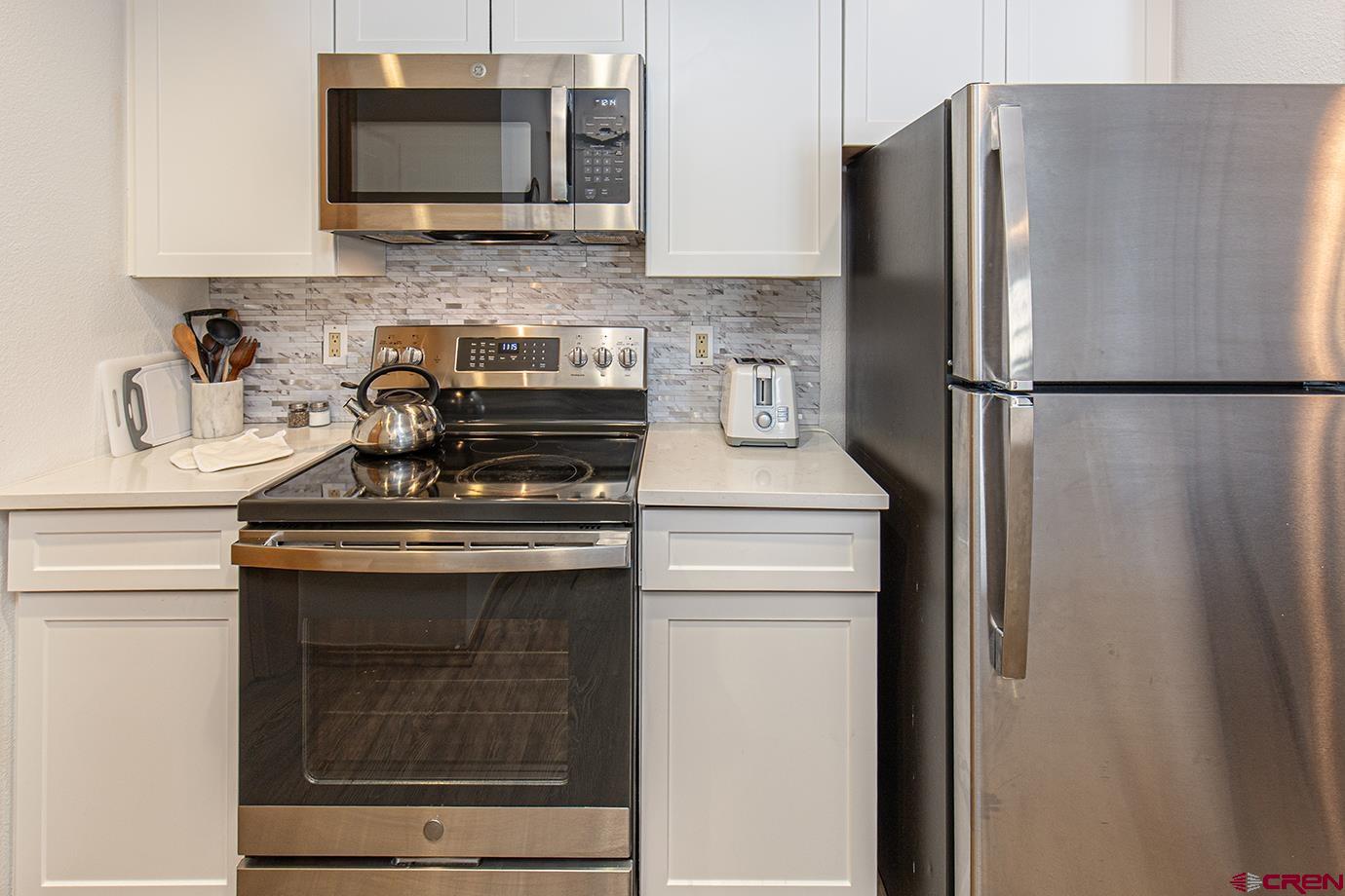 93 Needles Way, Unit 514 Durango, CO 81301 - Photo 6 of 34 a kitchen with stainless steel appliances a refrigerator stove and microwave
