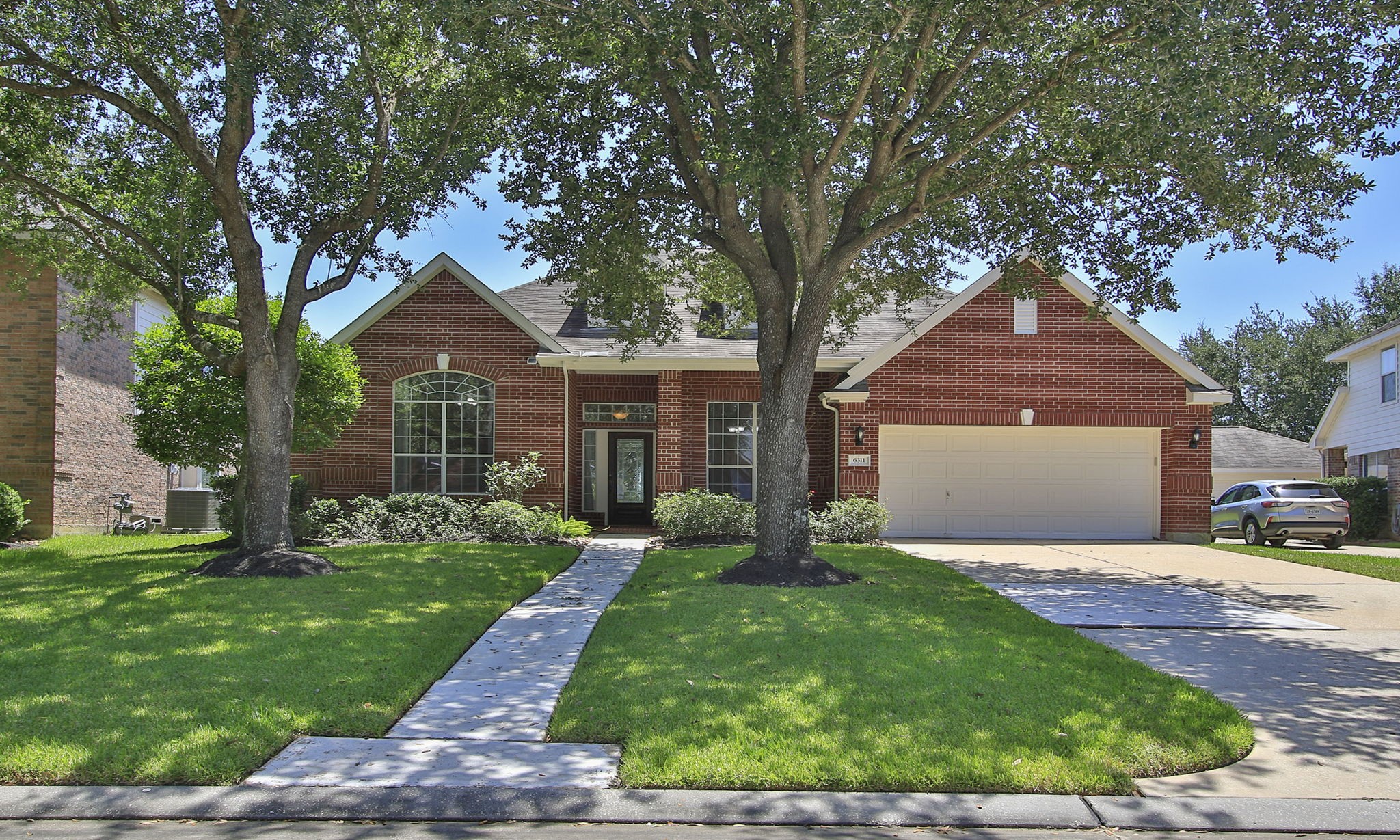 a front view of a house with a yard and pathway