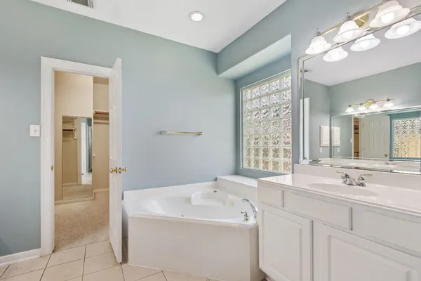 a spacious bathroom with a double vanity sink and a mirror