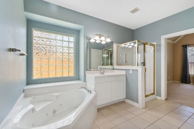 a bathroom with a tub a sink and a large mirror