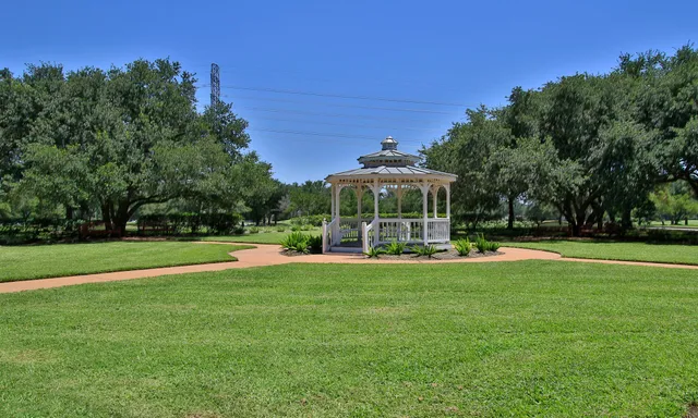 a view of a swimming pool with lawn chairs under an umbrella