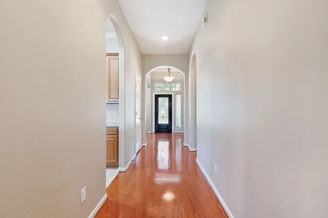 a view of a hallway with wooden floor