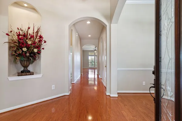 a view of a hallway with wooden floor and a potted plant