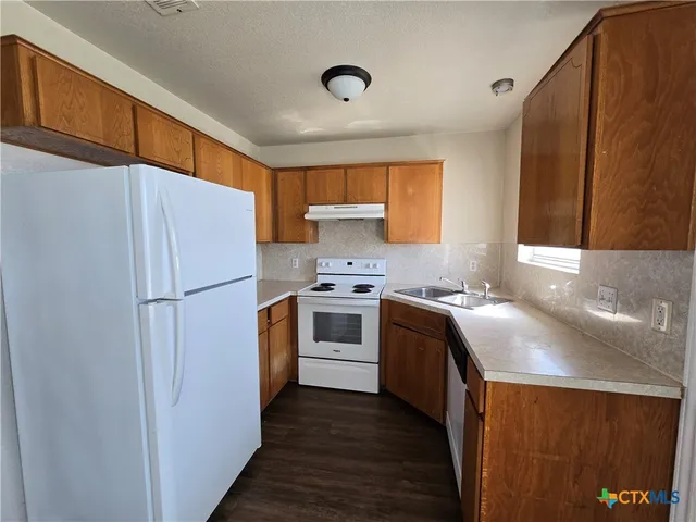 a kitchen with a white cabinets and white appliances
