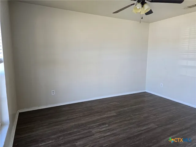 a view of a room with wooden floor and fan