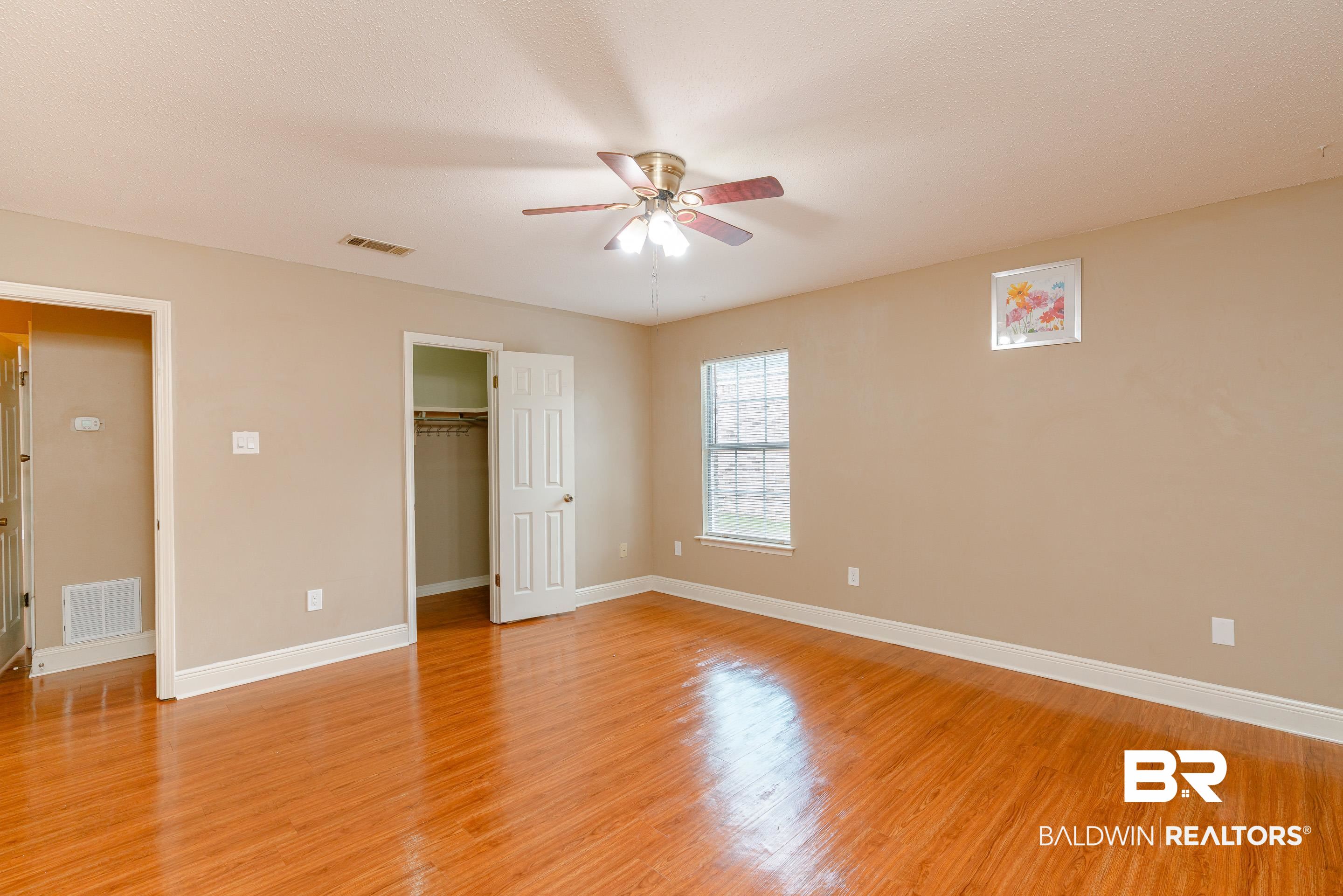 23 Old Mill Court Mobile, AL 36608 - Photo 25 of 37 Unfurnished bedroom featuring a closet, ceiling fan, light wood-type flooring, and a walk in closet