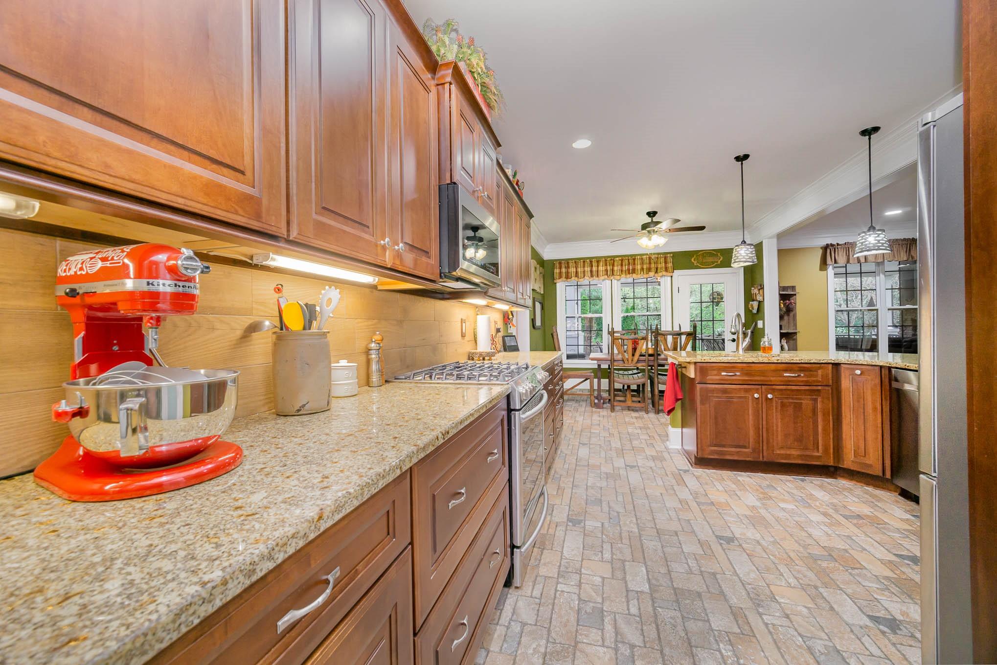 6700 Fox Ridge Circle Davidson, NC 28036 - Photo 8 of 48 a kitchen with kitchen island granite countertop wooden cabinets a sink and dishwasher
