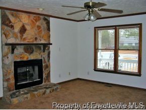 10223 Rockfish Road Raeford, NC 28376 - Photo 4 of 12 an empty room with windows and fireplace