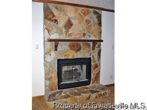10223 Rockfish Road Raeford, NC 28376 - Photo 6 of 12 a stone fireplace with a clock on wall