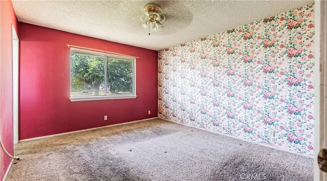 an empty room with windows and cabinet