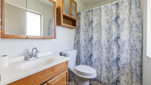 a view of a big room with wooden floor and a kitchen