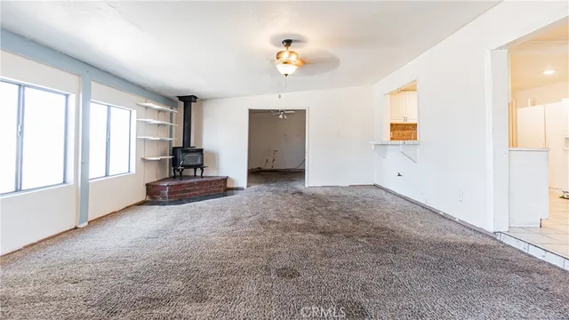 an empty room with a chandelier fan and closet