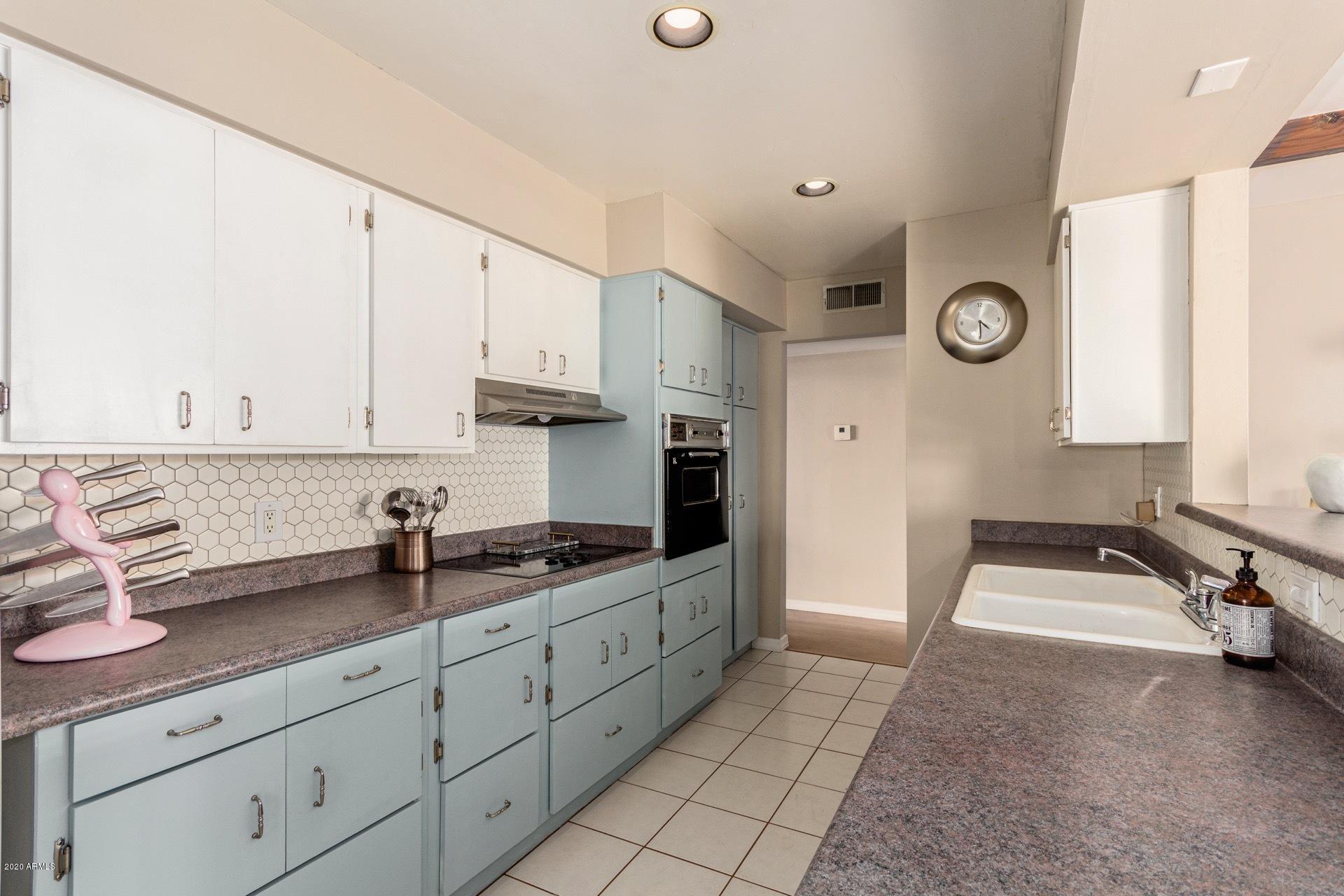 1732 North Queensbury Mesa, AZ 85201 - Photo 12 of 27 a kitchen with stainless steel appliances granite countertop a sink a stove and white cabinets