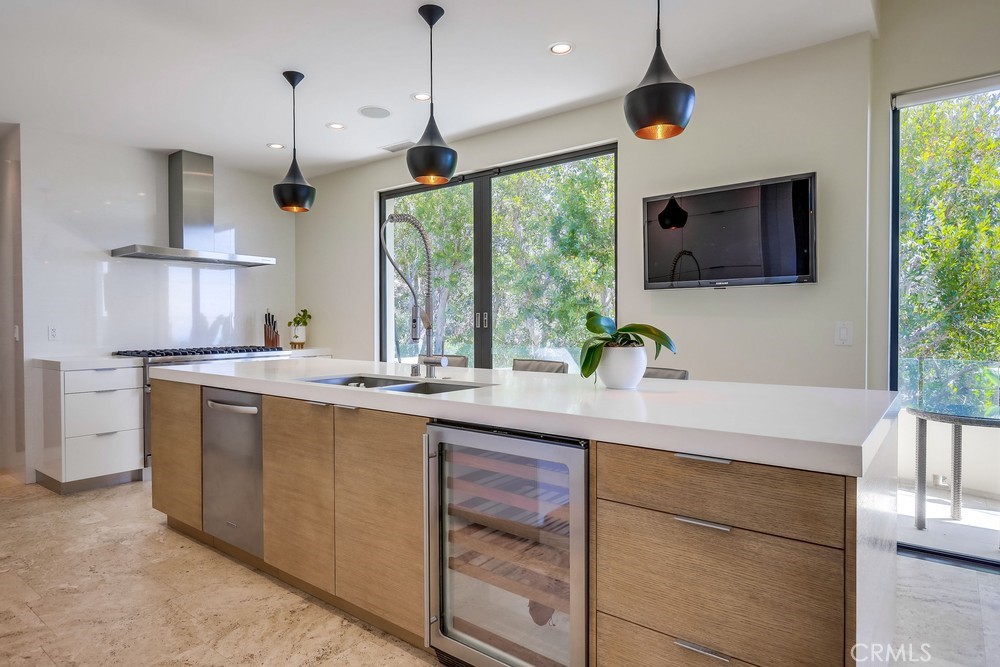 1725 Del Mar Avenue Laguna Beach, CA 92651 - Photo 26 of 63 a kitchen with kitchen island granite countertop a sink a counter top space appliances and cabinets