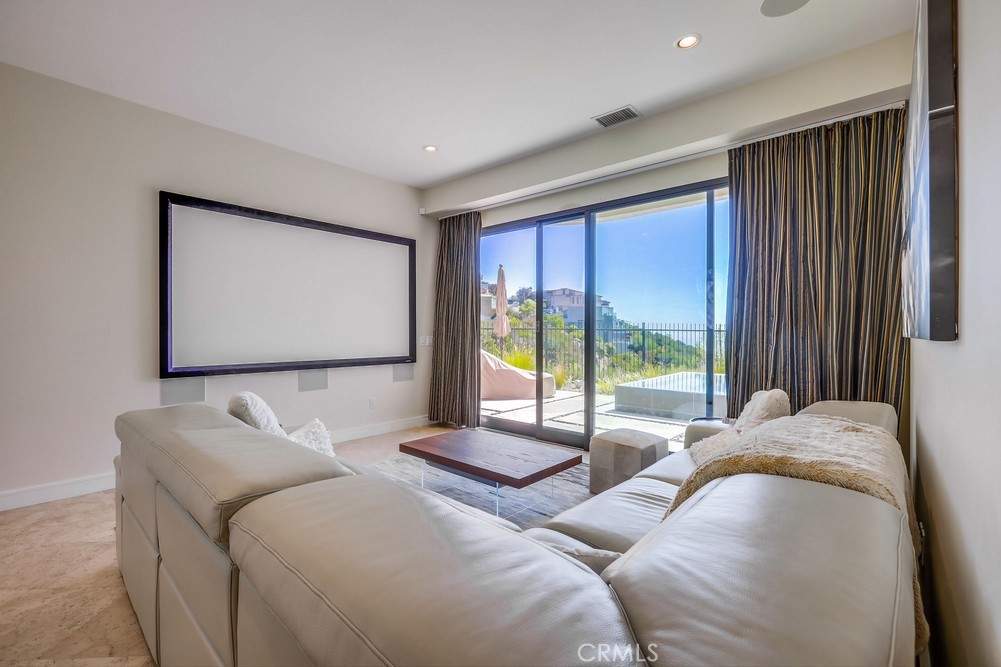 1725 Del Mar Avenue Laguna Beach, CA 92651 - Photo 44 of 63 a living room with couches large window and a flat screen tv
