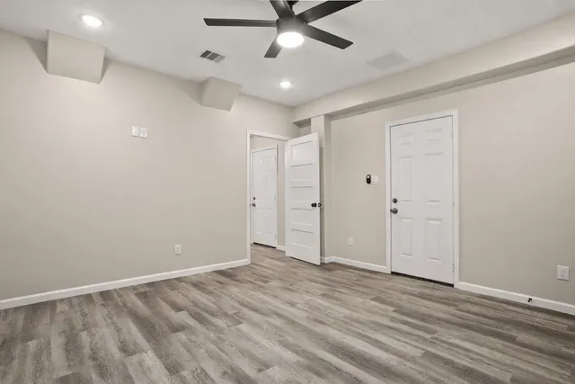 wooden floor in an empty room with a ceiling fan