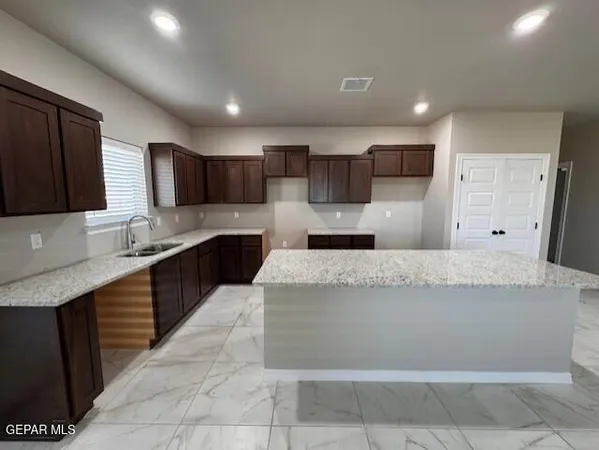 a large kitchen with stainless steel appliances kitchen island granite countertop a stove a sink a refrigerator and a microwave