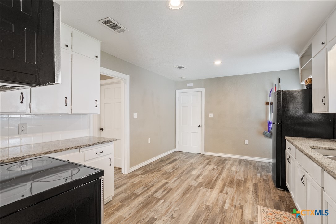 1206 Ashleman Street Waco, TX 76705 - Photo 12 of 26 a kitchen with granite countertop a stove and a sink