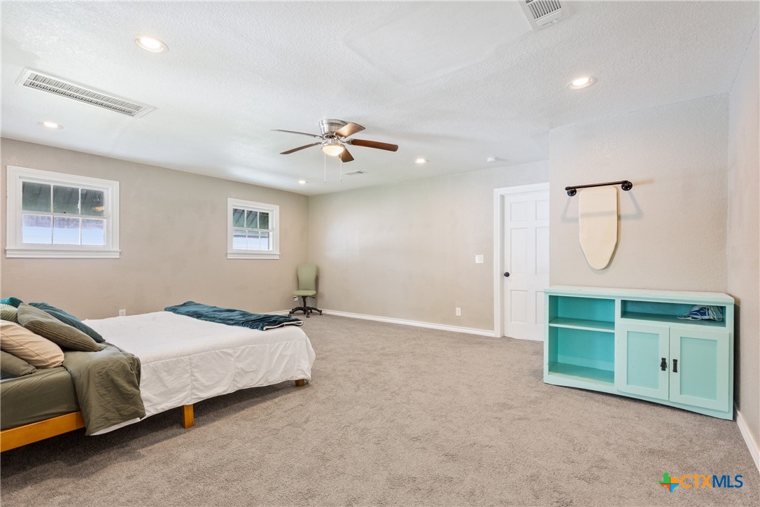 1206 Ashleman Street Waco, TX 76705 - Photo 14 of 26 a bedroom with a bed and a chandelier