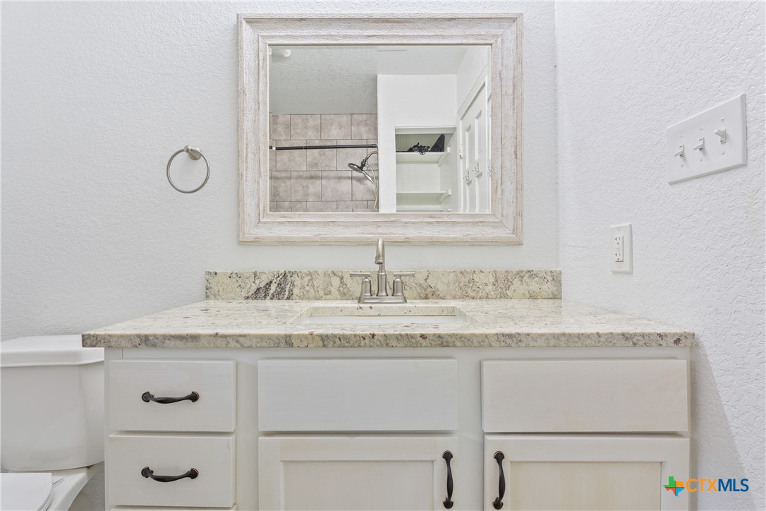 1206 Ashleman Street Waco, TX 76705 - Photo 15 of 26 a bathroom with a granite countertop sink vanity and mirror