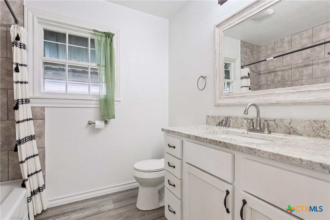 1206 Ashleman Street Waco, TX 76705 - Photo 16 of 26 a bathroom with a granite countertop sink toilet and shower