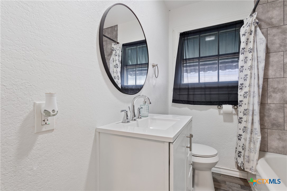 1206 Ashleman Street Waco, TX 76705 - Photo 20 of 26 a bathroom with a toilet a sink and a mirror