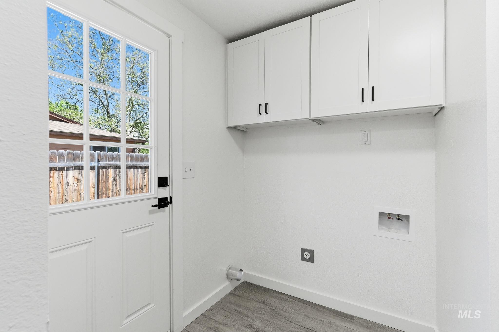 2224 Rachel Circle Boise, ID 83706 - Photo 38 of 50 Utility room featuring white shaker-style cabinetry with matte black hardware, wood-finish flooring, and an exterior door with divided light windows