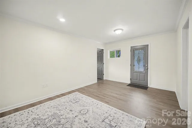 an empty room with wooden floor and window
