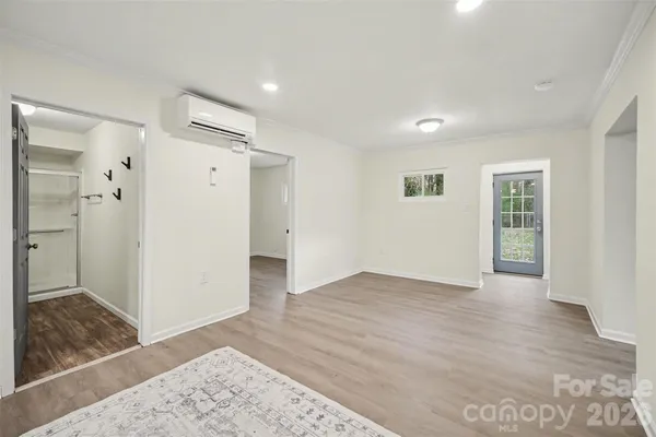 an empty room with wooden floor and a bathroom