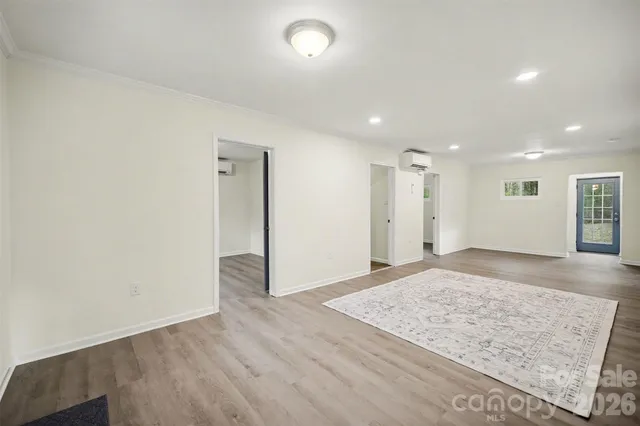 an empty room with wooden floor and window