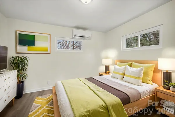 a bedroom with a bed and a lamp on dresser