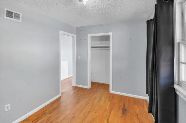 an empty room with wooden floor and closet