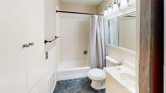 a bathroom with a toilet and a shower