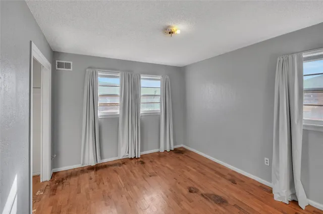 a view of a room with wooden floor and window