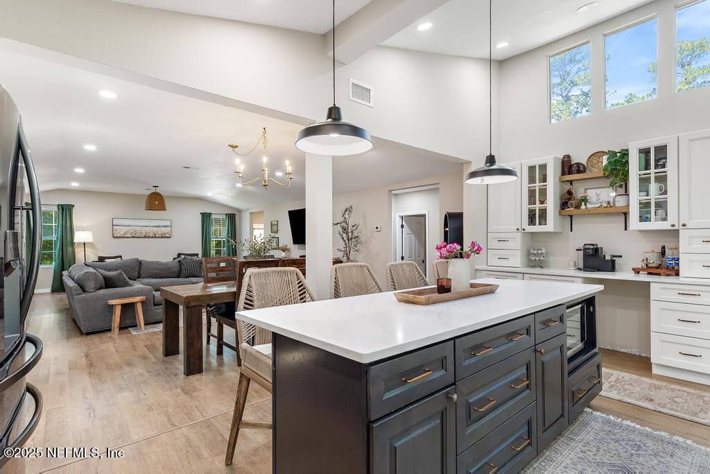 86290 Weldon Road Yulee, FL 32097 - Photo 16 of 50 a kitchen with a stove a sink a dining table and chairs