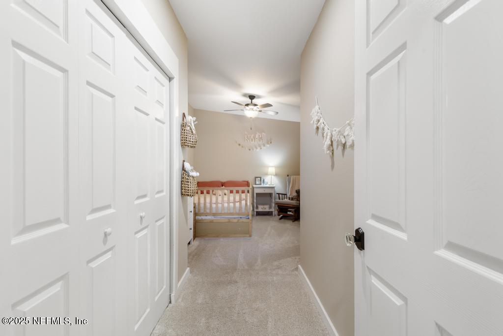 86290 Weldon Road Yulee, FL 32097 - Photo 20 of 50 a view of a hallway with a livingroom and a bathroom with a sink
