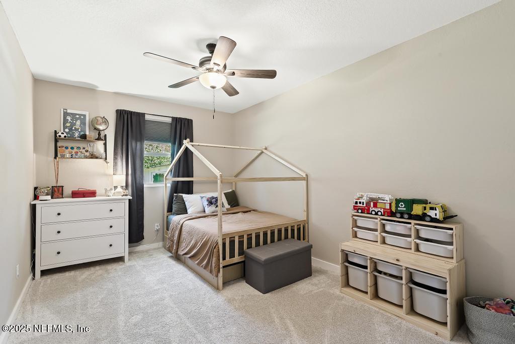 86290 Weldon Road Yulee, FL 32097 - Photo 27 of 50 a bedroom with a bed and a chandelier