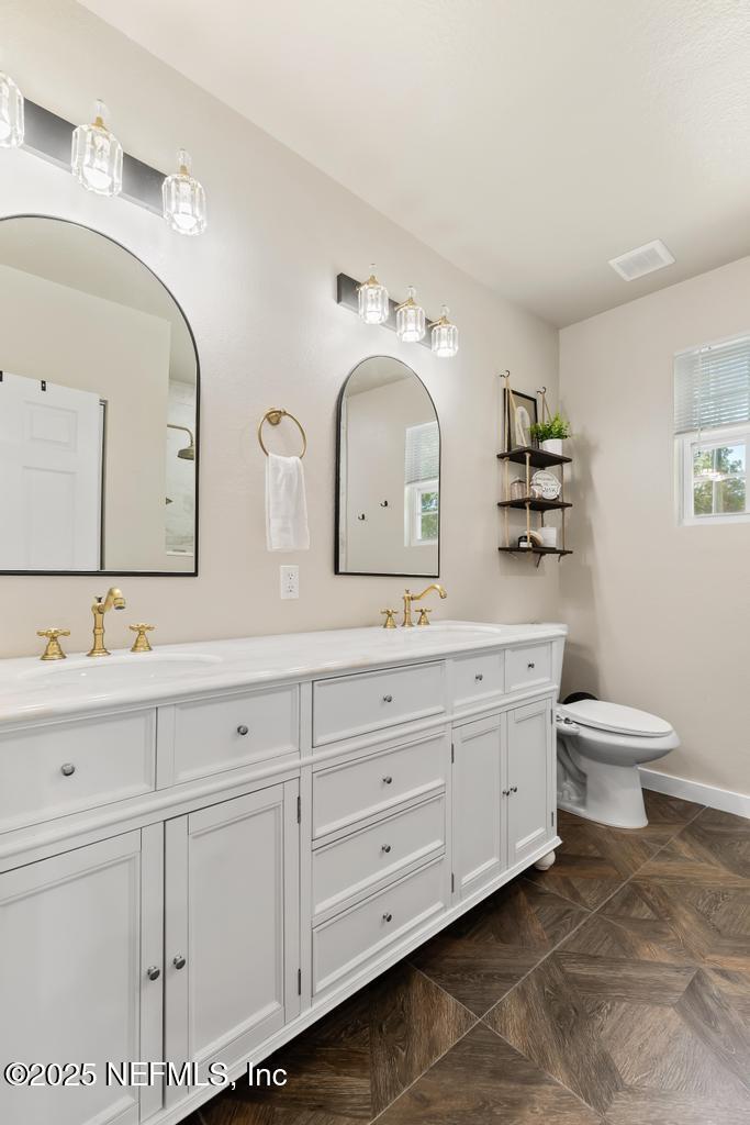 86290 Weldon Road Yulee, FL 32097 - Photo 31 of 50 a bathroom with a toilet sink and mirror