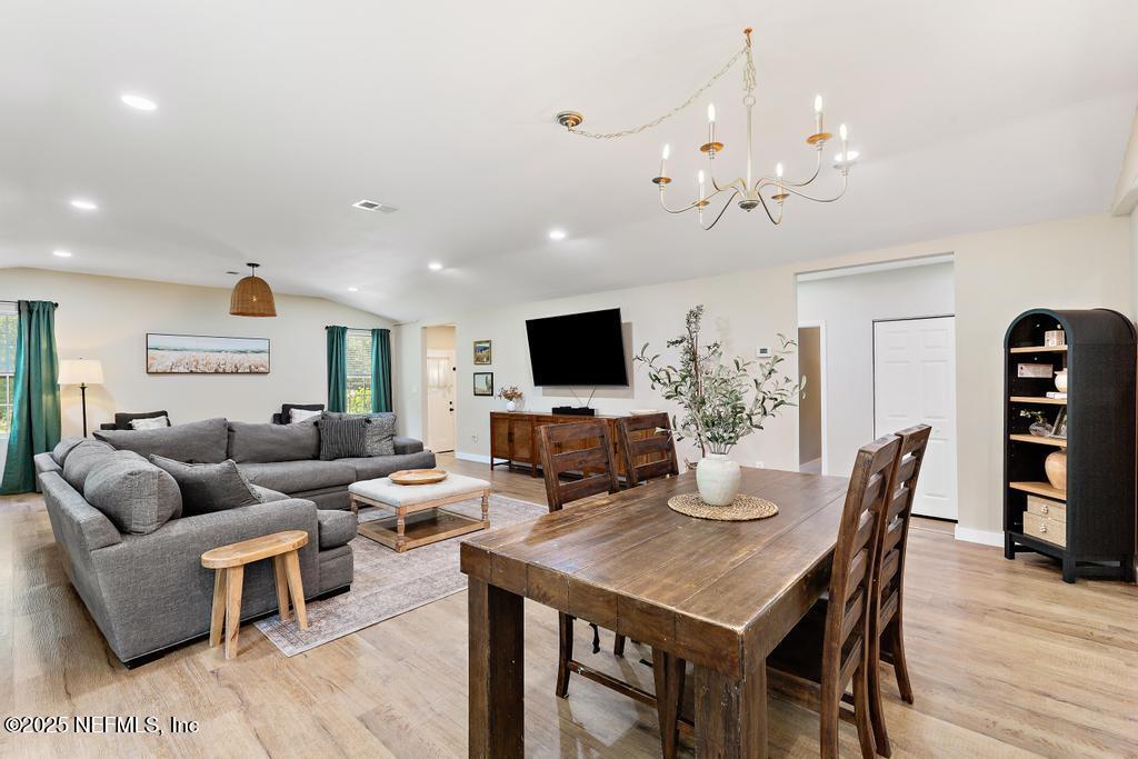 86290 Weldon Road Yulee, FL 32097 - Photo 9 of 50 a living room with furniture a flat screen tv and kitchen view