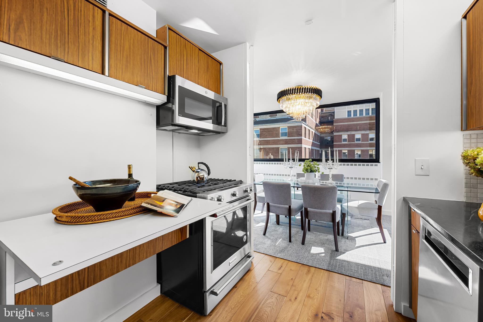 4000 North Charles Street, Unit 1414 Baltimore, MD 21218 - Photo 11 of 45 a kitchen with stainless steel appliances a stove a sink dishwasher and white cabinets with wooden floor