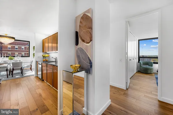 a kitchen with stainless steel appliances wooden floor and a refrigerator