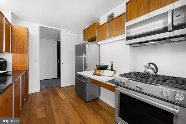 a kitchen with stainless steel appliances granite countertop a stove a sink and a refrigerator