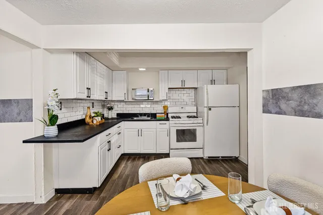 a kitchen with white cabinets and white appliances