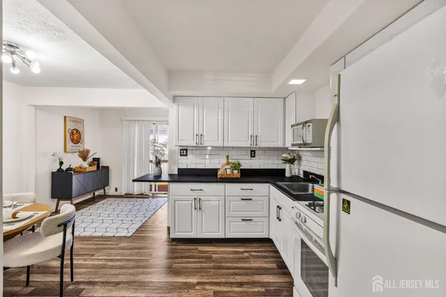 a kitchen with stainless steel appliances kitchen island granite countertop a stove refrigerator and cabinets