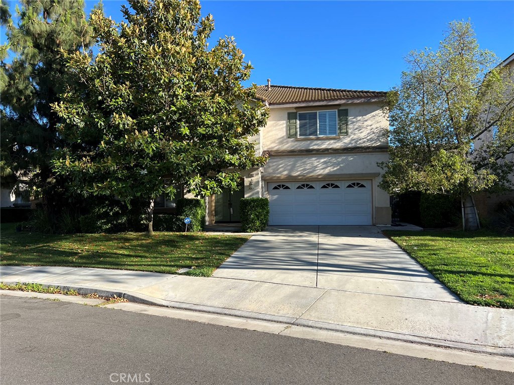 13837 Blue Ribbon Lane Eastvale, CA 92880 - Photo 1 of 1 a front view of a house with a yard
