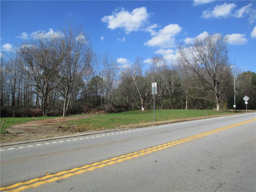 a view of a house with a big yard and a large trees
